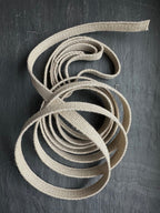 natural hemp webbing fabric strap on a dark gray background