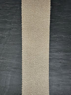 Beige woven natural hemp webbing strip on a dark textured background