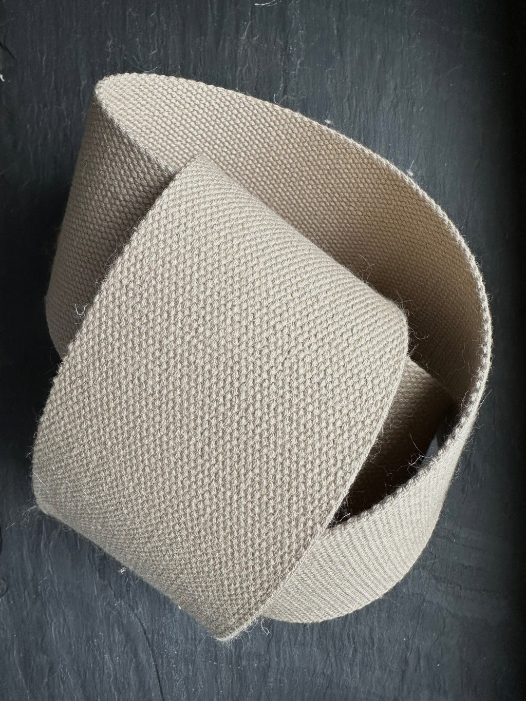 natural hemp webbing piece close up on a dark surface