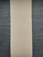 Beige woven hemp webbing strip on a dark textured surface