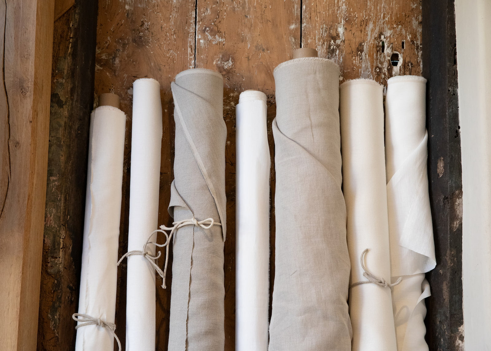 Rolls of hemp fabric against a wooden door
