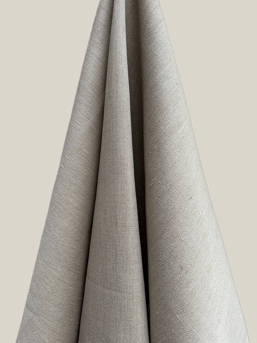 Cairn natural hemp twill fabric draped over a neutral background