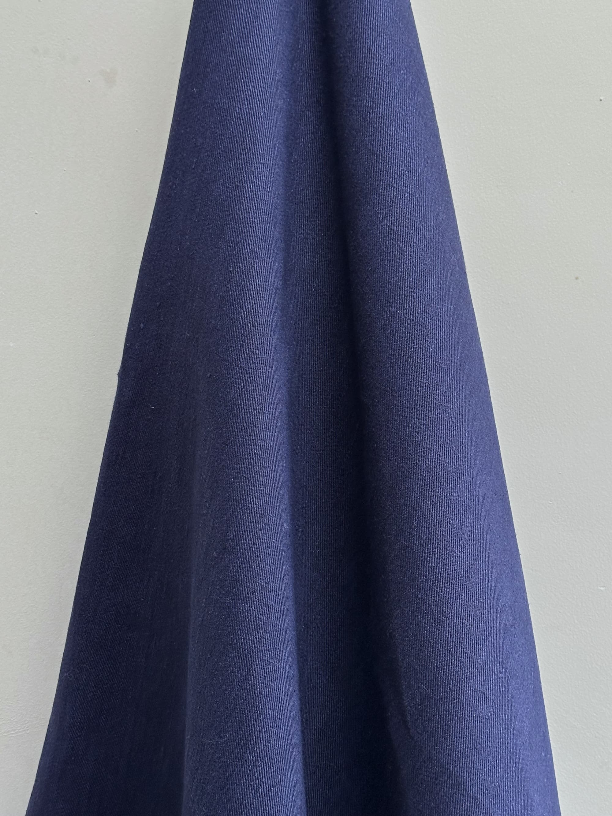 Cairn Indigo blue hemp fabric hung on a light gray background