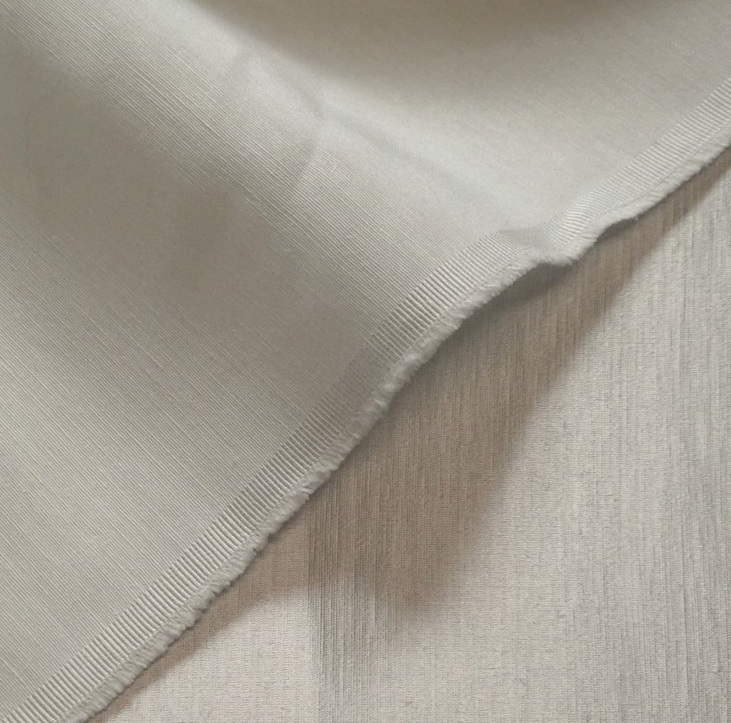 close up of satin hemp silk fabric in cream with texture