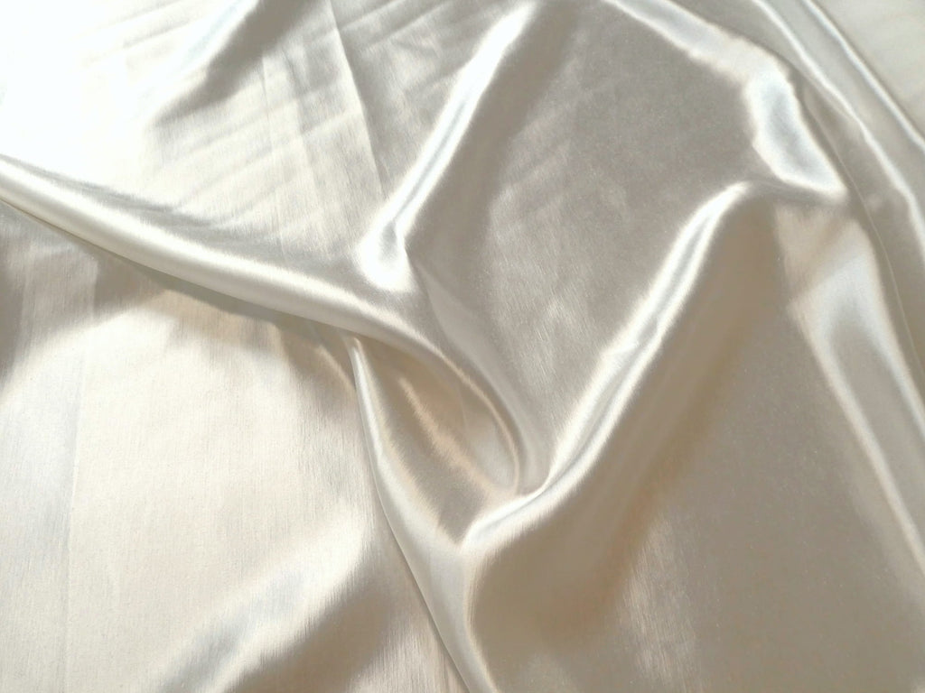 Close-up of cream charmeuse hemp and silk fabric with folds
