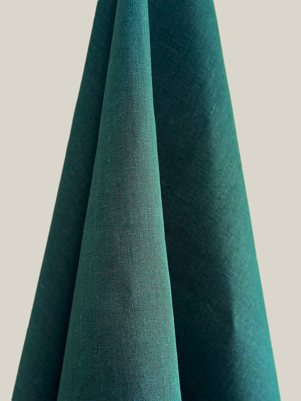 Dama Teal hemp fabric draped over a neutral background
