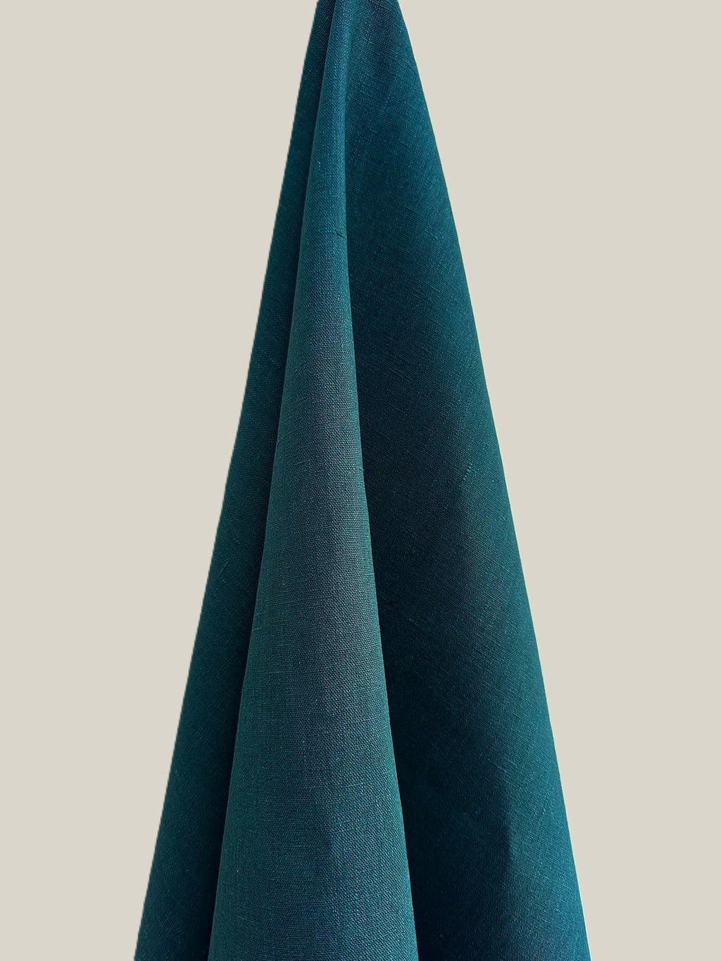 Dama Teal hemp fabric hung against a neutral background
