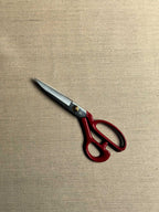 Hampa herringbone hemp fabric laid flat with pair of red handled scissors