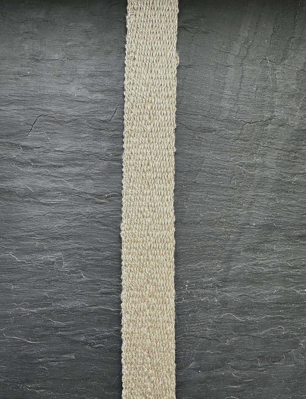 Herringbone hemp natural webbing strip on dark slate background