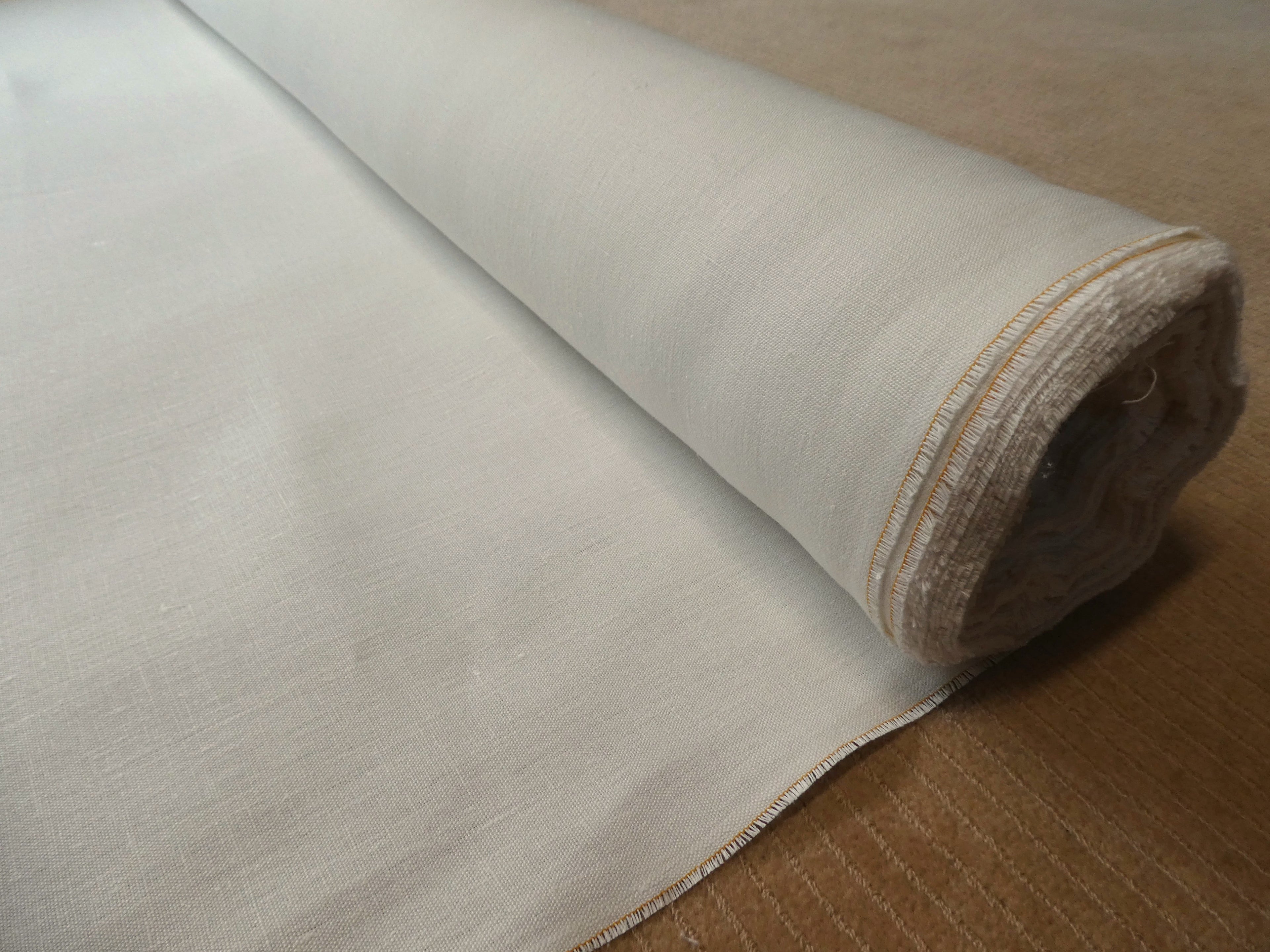 Mesa hemp and cotton canvas fabric roll against beige carpet background