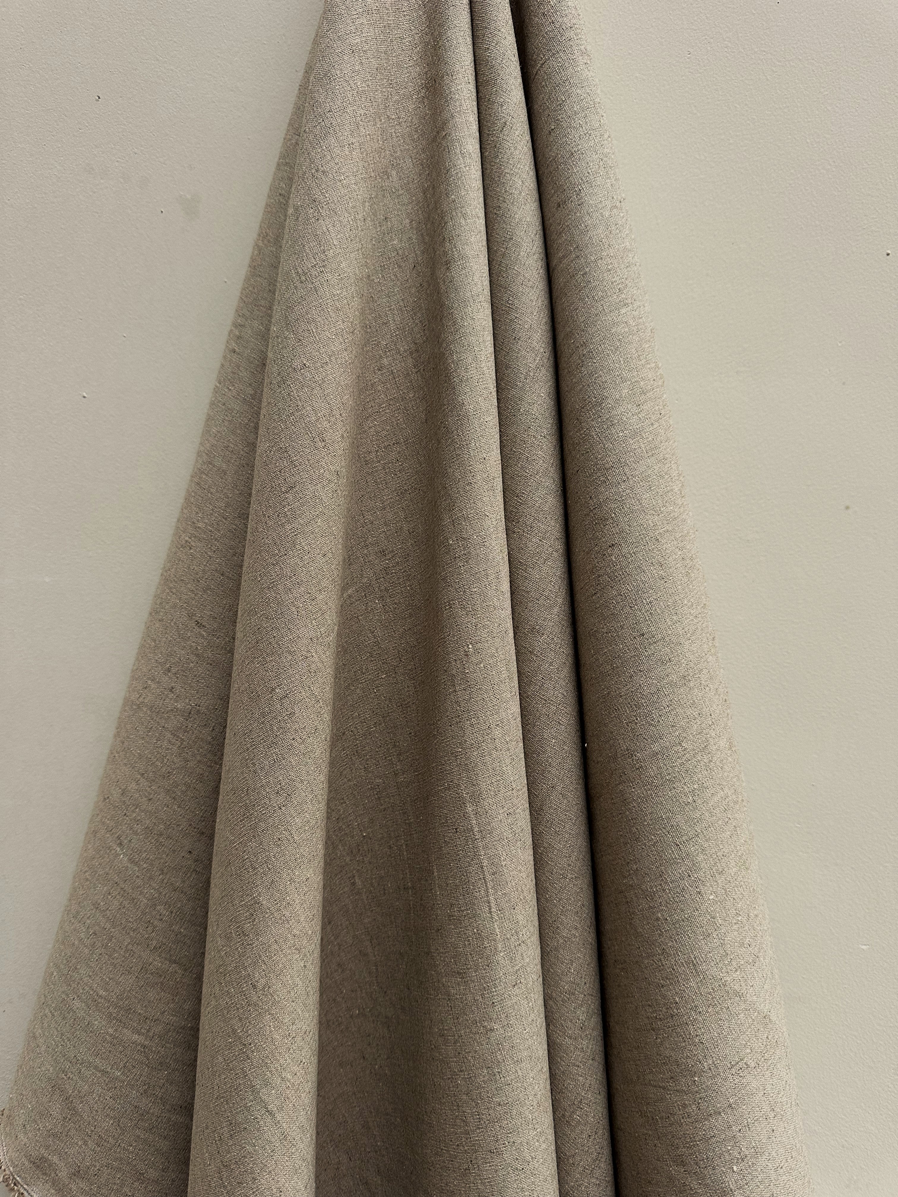 Sorrel natural hemp fabric hung against a neutral wall
